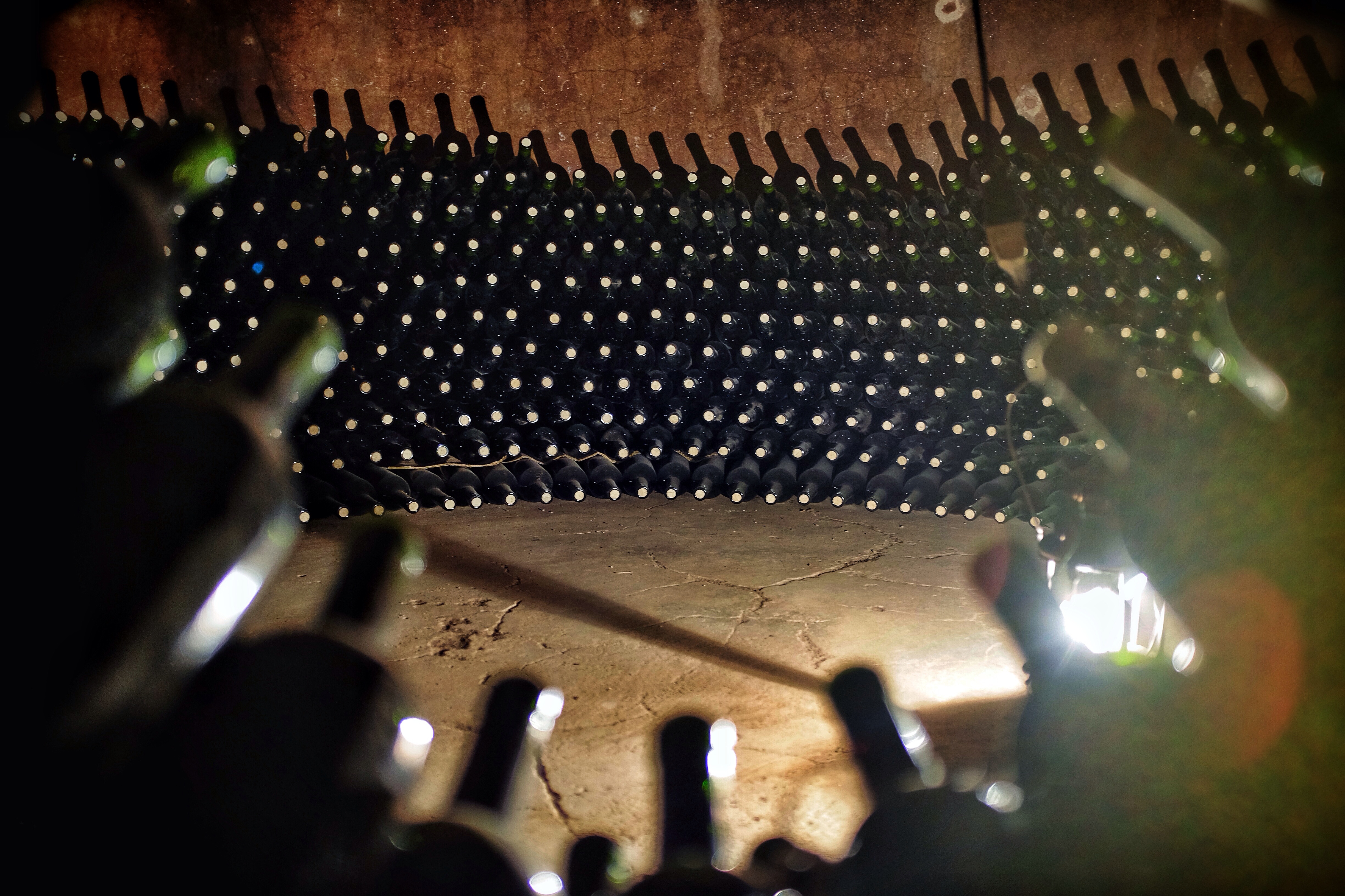 Bottles aging in the old vats of  the Famila di Tommaso bodega (winery).