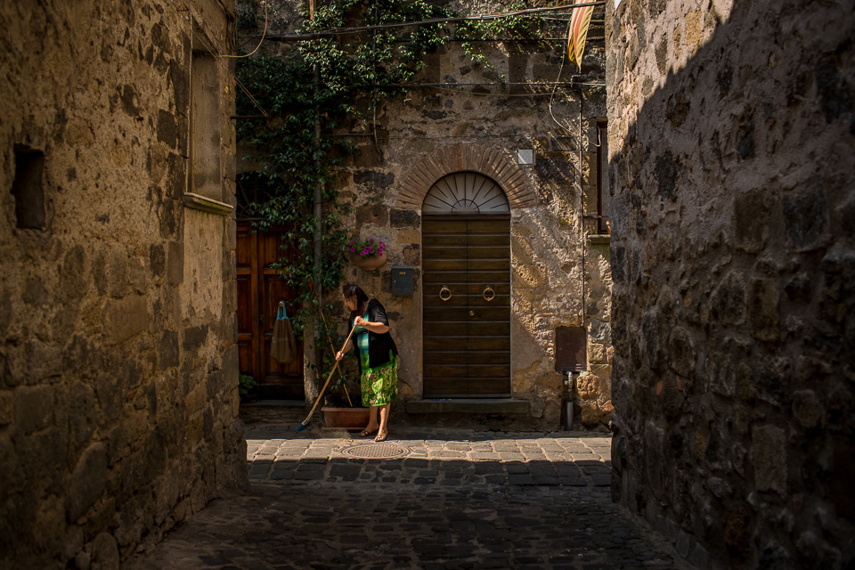 A woman sweeping up in Bolsena.